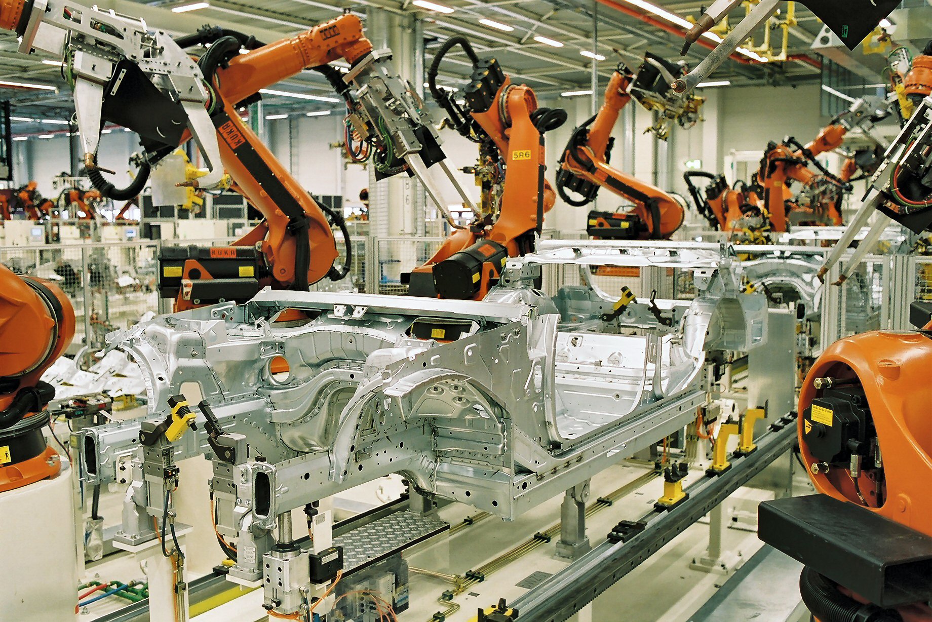 Robot arms welding a car body on an assembly line